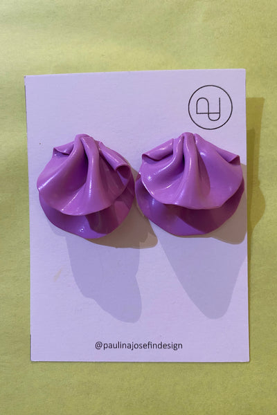 A pair of lilac ruffled Paulina Josefin design earrings from BUTIK KUBIK displayed on a white card with a round Paulina Josefin logo and @paulinajosefindesign, set against a pale yellow background.