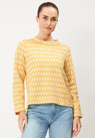 A person wears the Jumperfabriken Saralisa Jumper Yellow by BUTIK KUBIK and light blue jeans against a plain background, with hair tied back, looking neutrally at the camera.