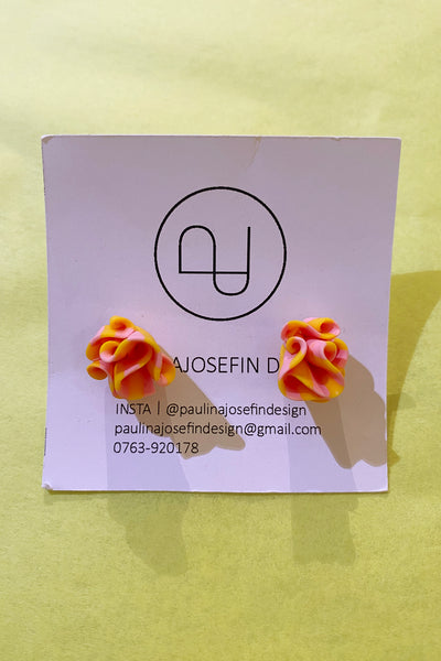 Paulina Josefin design earrings by BUTIK KUBIK feature ruffled yellow and pink polymer clay petals, displayed on a logo card with contact info against a pale yellow background.