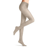 A person, shown from the waist down against a white background, models Falke cotton Family Rib Beige tights by BUTIK KUBIK, standing on one foot with the other leg bent slightly backward.