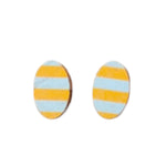 The Törmi earrings Juova mint/yellow by BUTIK KUBIK are oval-shaped and made from Finnish Birch plywood, featuring horizontal stripes in alternating light blue and yellow on a white background. They arrive in eco-friendly packaging for a thoughtful touch.