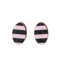 The Törmi earrings Juova pink/black, designed by BUTIK KUBIK, feature a striking pink and black striped pattern on Finnish Birch plywood. These oval-shaped earrings arrive in eco-friendly packaging, showcasing a commitment to sustainability.