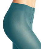 A close-up side view shows a person wearing Falke pure matte Peacock leggings by BUTIK KUBIK. The high-waisted, teal leggings feature smooth, stretchy fabric that fits snugly, resembling 50 den matte pantyhose against a plain background.