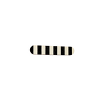 A Törmi Viiru hair clip from BUTIK KUBIK, designed with black and white vertical stripes and rounded edges, sits centrally against a plain white background.