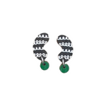 The Törmi papu mini earrings by BUTIK KUBIK are crafted from Finnish Birch plywood, featuring a stylized black design with white loops and small green circular accents, set against a white background.