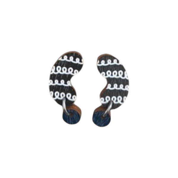 The Törmi papu mini earrings by BUTIK KUBIK feature abstract black and white curved shapes with wavy patterns, crafted from Finnish Birch plywood. Theyre attached to round dark blue posts and come in eco-friendly packaging.