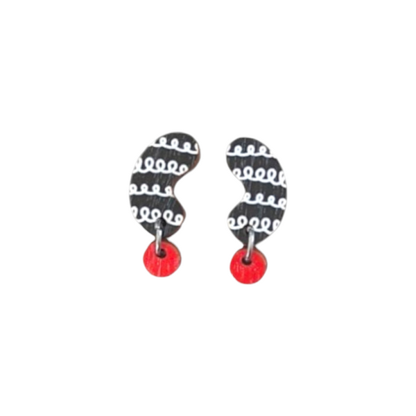 The Törmi Papu mini earrings by BUTIK KUBIK showcase asymmetrical black shapes with white swirls, attached to small red circles. Made from Finnish Birch plywood and finished with surgical steel hooks, they come in eco-friendly packaging for sustainability.