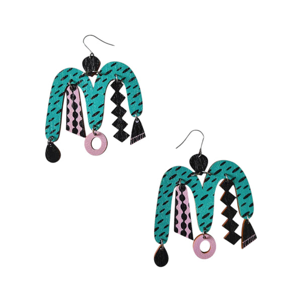 The Törmi Karnevaali Earrings in turquoise/lavender by BUTIK KUBIK are vibrant, abstract accessories made from Finnish birch plywood, featuring geometric designs and eco-friendly packaging.