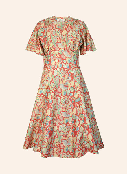 The BUTIK KUBIK Rita Long-sleeve Dress in Dark Coral Shells features a knee-length, fitted waist, flared skirt, and airy Tencel fabric with a vibrant shell print—perfect for strolls by the British coast.