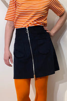 A person wearing a BUTIK KUBIK Kubik corduroy zip skirt nr 1 and orange tights.