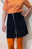 A person wearing a BUTIK KUBIK Kubik corduroy zip skirt nr 1 and orange tights.