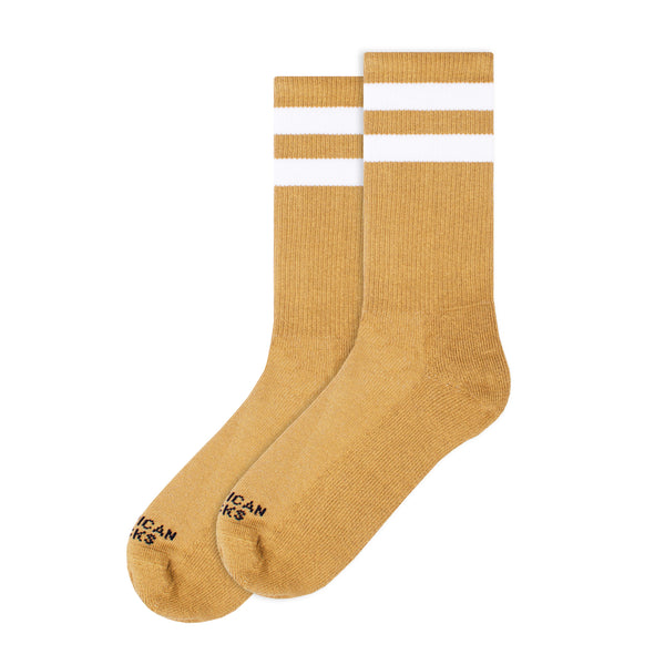 BUTIK KUBIKs American Socks Mid High Mustard are vegan-friendly crew socks in mustard yellow with two white stripes and black text near the toes, perfect for stylish comfort on or off your board.