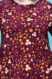 A purple long-sleeved Cissi och Selma dress Ingrid Kaprisblomma plommon with an orange and white floral and vine pattern, designed as a comfortable casual dress.