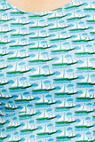 Close-up of soft ekologisk bomullstrikå fabric in the Cissi och Selma Asta Havsbris design by BUTIK KUBIK, featuring white sailboats on blue water under a light blue sky with stylized clouds; boats are arranged in rows across the predominantly blue background.