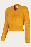 Introducing the Emmy - The Scandi Summer Cardi in turmeric by BUTIK KUBIK: a vibrant yellow merino wool cardigan with a V-neck, classic cable-knit pattern, and long sleeves. This vintage-inspired piece features ribbed hem and cuffs, plus a button-up front. Displayed on a plain background.