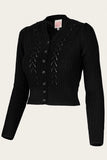 The Emmy - The Scandi Summer Cardi by BUTIK KUBIK is a classic black knit cardigan with a V-neck, intricate patterns, puffed shoulders, thick textured merino wool, matching black buttons, and long sleeves—timeless design.