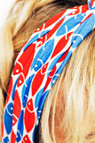 Close-up of blonde hair wearing the BUTIK KUBIK Cissi och Selma Hedda headband Mört, made from LENZING™ ECOVERO™ viskostrikå, showcasing a playful red, white, and blue fish pattern covering part of the head.