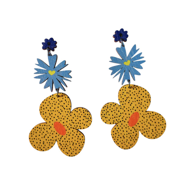 The Törmi Kimara earrings blue/yellow by BUTIK KUBIK are lightweight Finnish Birch plywood earrings with blue star-shaped flowers and large yellow flowers, thoughtfully crafted and shipped in eco-friendly packaging.