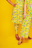 Two people, seen from the shoulders down, stand against a yellow background wearing matching yellow floral Cissi och Selma outfits. One wears BUTIK KUBIK’s Cissi och Selma Lo Leggings Humlesurr gul made from ekologisk bomull with tan platform sandals.