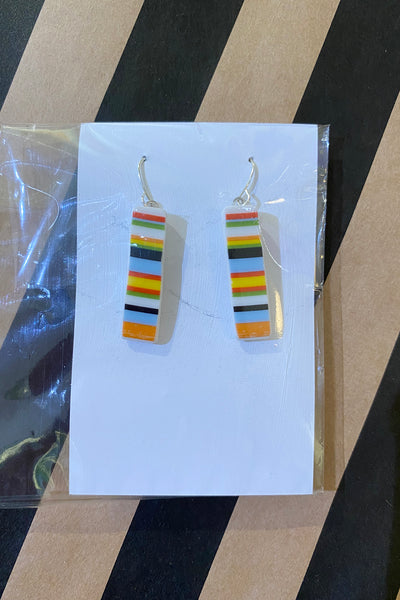 Saved & Remade earrings by BUTIK KUBIK: rectangular dangle earrings made from upcycled porcelain, with multicolored horizontal stripes—shown on a white card with a striped background.