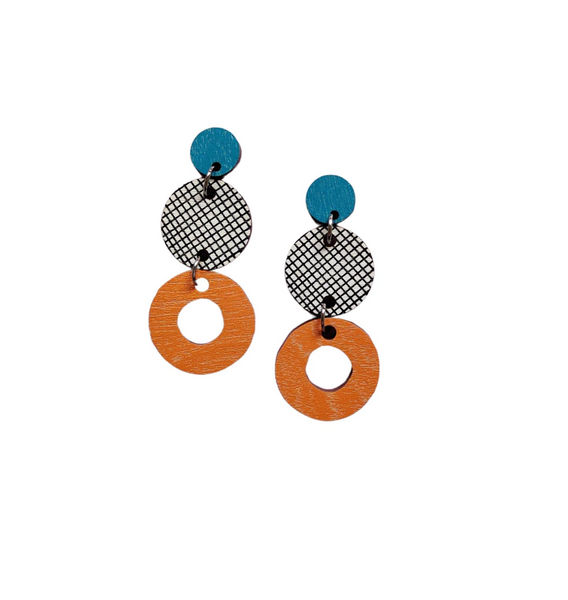 The Törmi herkku earrings by BUTIK KUBIK feature Finnish birch plywood with a blue circle, black-and-white mesh center, and orange ring. Finished with surgical steel and shipped eco-friendly.